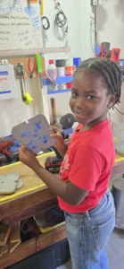 A student from the Newfield Primary School holding up a mold of upcycled plastic keychains