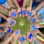 Participants from Adopacoastline holding bottlecaps and the sea creatures they made in their hands