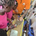Students from the Sea View Farm Primary School open the molds in the workshop