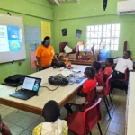 WISH Intern J'herdine speaks with a class of students at the Newfield Primary School