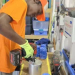 Workshop intern Keamoy closing the molds